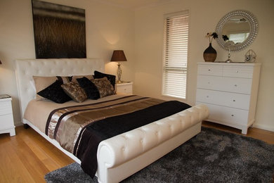 Diseño de dormitorio principal actual con suelo de madera clara