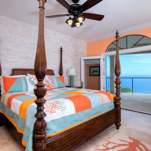 Modelo de habitación de invitados tropical, grande, con parades naranjas, suelo de travertino y suelo beige