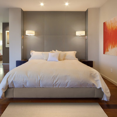 Example of a minimalist medium tone wood floor bedroom design in Orlando with white walls