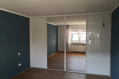 Aménagement d'une chambre parentale contemporaine avec un mur bleu et un sol en vinyl.