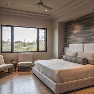 Großes Modernes Hauptschlafzimmer mit beiger Wandfarbe, braunem Holzboden, Gaskamin und Kaminumrandung aus Beton in Phoenix