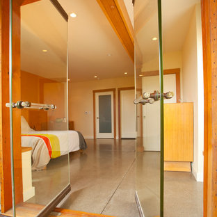Diseño de dormitorio contemporáneo con suelo de cemento y paredes blancas