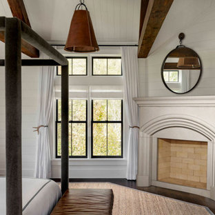Foto de dormitorio principal, machihembrado y madera, de estilo de casa de campo, de tamaño medio, madera, con paredes grises, suelo de madera oscura, todas las chimeneas, marco de chimenea de hormigón, suelo marrón y madera