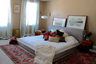 他の地域にあるトランジショナルスタイルのおしゃれな主寝室 (ベージュの壁、カーペット敷き、グレーの床) のインテリア