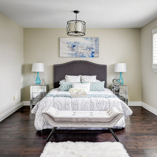 Idee per un'ampia camera matrimoniale chic con pareti beige, parquet scuro, camino sospeso, cornice del camino in intonaco e pavimento marrone