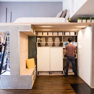 Ispirazione per una piccola camera da letto stile loft industriale con pareti grigie, pavimento in legno massello medio e nessun camino