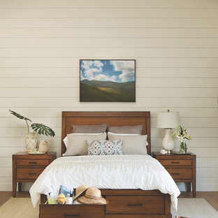 Imagen de habitación de invitados tropical, de tamaño medio, sin chimenea, con paredes blancas y suelo de madera en tonos medios