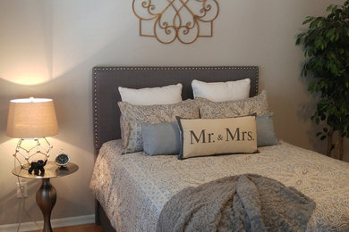 Modelo de dormitorio principal romántico de tamaño medio sin chimenea con paredes grises y suelo de madera en tonos medios