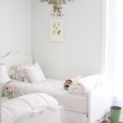 Inspiration for a shabby-chic style guest light wood floor bedroom remodel in Other with white walls