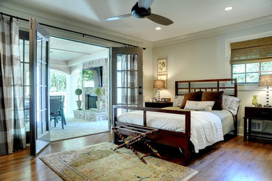 Modelo de dormitorio tradicional con paredes grises y suelo de madera en tonos medios