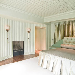 Example of a large 1960s master medium tone wood floor and brown floor bedroom design in Charlotte with green walls and a standard fireplace