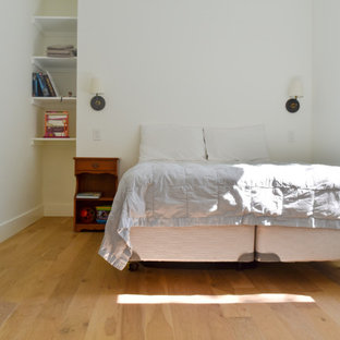 Foto de dormitorio tipo loft, tradicional, de tamaño medio, con paredes blancas, suelo laminado y suelo marrón