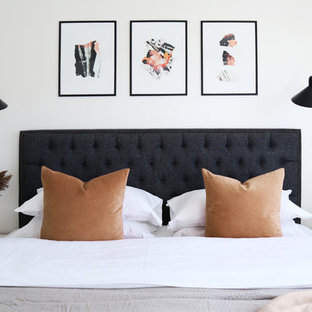 This is an example of a contemporary bedroom in London with white walls.