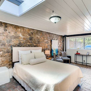 Ispirazione per una camera da letto stile americano con pareti bianche, pavimento in mattoni, camino ad angolo e pavimento rosso