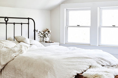 Foto de dormitorio campestre con paredes blancas y suelo de madera en tonos medios