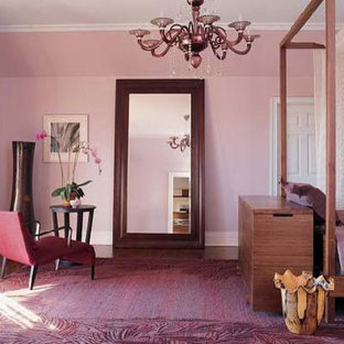 Modelo de dormitorio principal, actual, de tamaño medio, sin chimenea, con paredes púrpuras y suelo de madera en tonos medios