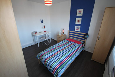 Cette image montre une chambre traditionnelle de taille moyenne avec un mur blanc et parquet foncé.