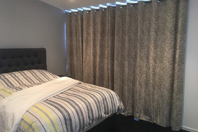 Foto de dormitorio principal moderno grande con paredes blancas y suelo gris