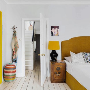 Diseño de dormitorio bohemio, de tamaño medio, con suelo de madera clara y paredes grises
