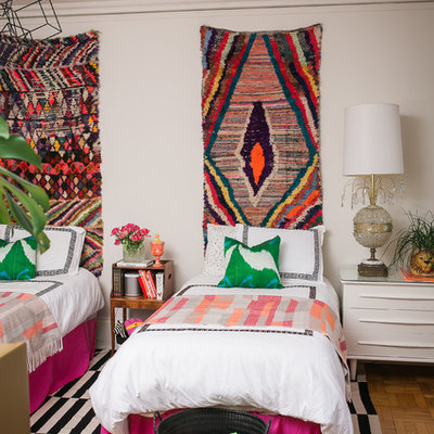 Eclectic guest medium tone wood floor bedroom photo in Chicago with white walls and no fireplace