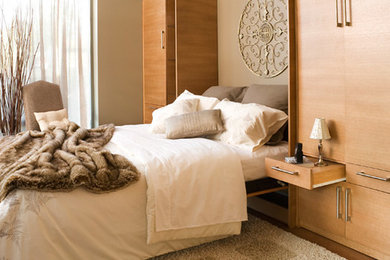 Diseño de habitación de invitados contemporánea grande sin chimenea con paredes beige y suelo de madera clara
