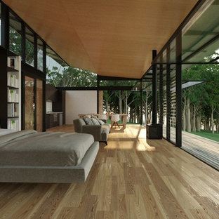 Modelo de dormitorio minimalista, pequeño, con paredes marrones y suelo de madera clara