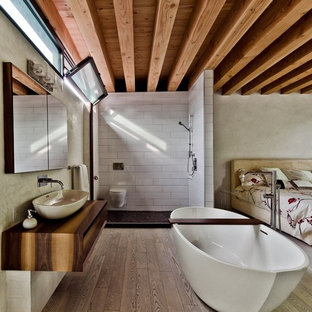 Immagine di una camera matrimoniale moderna con pareti beige e parquet chiaro