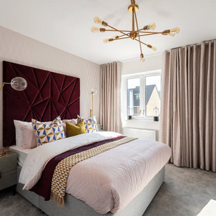 Photo of a contemporary bedroom with pink walls, carpet and grey floors.