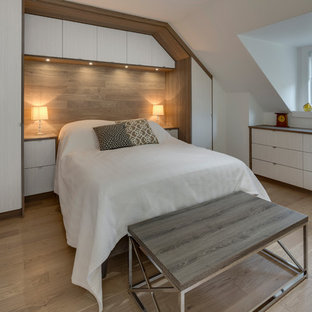 Foto de dormitorio contemporáneo, de tamaño medio, con paredes blancas, suelo laminado, chimeneas suspendidas, marco de chimenea de baldosas y/o azulejos y suelo marrón