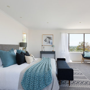 Beach style master bedroom in Sydney with beige walls, carpet and grey floor.