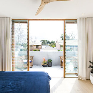 Contemporary master bedroom in Sydney with white walls, light hardwood floors and beige floor.