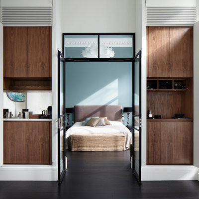 Large trendy master dark wood floor bedroom photo in London with blue walls