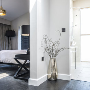 Modelo de dormitorio principal, contemporáneo, grande, con suelo de bambú, paredes beige y suelo negro