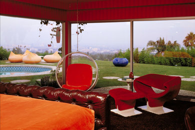 Aménagement d'une chambre contemporaine de taille moyenne avec un mur rouge, aucune cheminée et un sol marron.