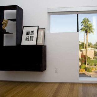 Imagen de dormitorio principal, minimalista, extra grande, con paredes blancas, suelo de bambú, chimeneas suspendidas y marco de chimenea de metal
