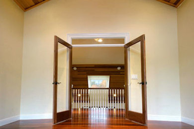 Imagen de dormitorio principal con paredes beige y suelo de madera en tonos medios