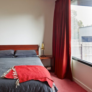 Ispirazione per una camera da letto minimal con pareti bianche, moquette e pavimento rosso