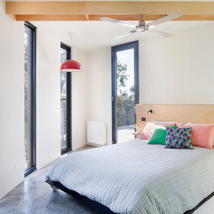 This is an example of a mid-sized scandinavian bedroom in Geelong with white walls, grey floor and concrete floors.