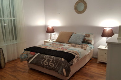 Imagen de dormitorio clásico pequeño sin chimenea con paredes blancas y suelo de madera en tonos medios