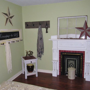 Foto de habitación de invitados de estilo de casa de campo, de tamaño medio, con paredes verdes, suelo de madera oscura, chimenea tradicional y marco de chimenea de baldosas y/o azulejos