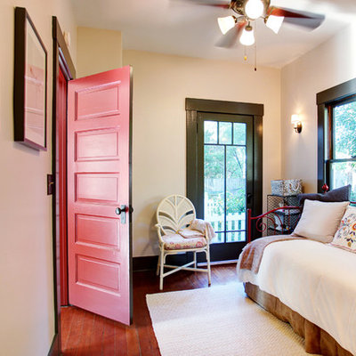 Cottage guest medium tone wood floor bedroom photo in Los Angeles with beige walls
