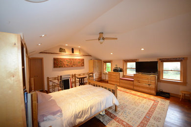 他の地域にある広いラスティックスタイルのおしゃれな主寝室 (白い壁、濃色無垢フローリング、暖炉なし、茶色い床)