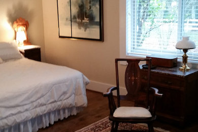 Example of a mid-sized classic master dark wood floor and brown floor bedroom design in Houston with beige walls and no fireplace