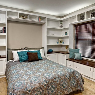 Ispirazione per una grande camera da letto design con pareti beige, parquet chiaro, nessun camino e pavimento marrone