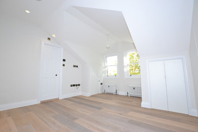 Imagen de dormitorio principal contemporáneo de tamaño medio con paredes grises, suelo de madera en tonos medios y suelo marrón