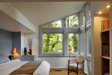 Diseño de dormitorio principal contemporáneo de tamaño medio sin chimenea con suelo de madera en tonos medios y paredes blancas
