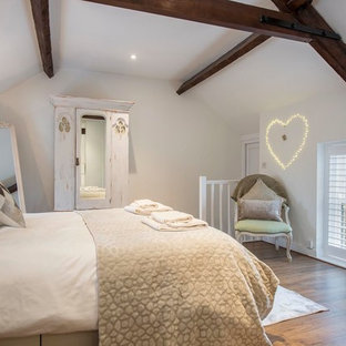 Photo of a medium sized farmhouse bedroom in Other with white walls, medium hardwood flooring and brown floors.