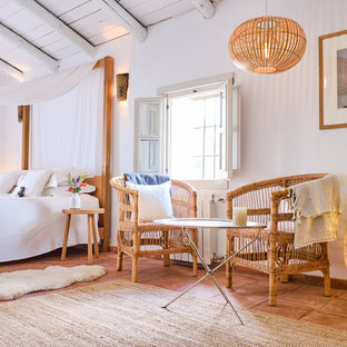 Design ideas for a country bedroom in London with white walls, terracotta flooring and brown floors.