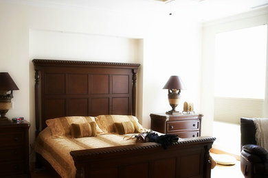 Foto di una camera matrimoniale chic di medie dimensioni con pareti bianche, pavimento in legno massello medio e nessun camino