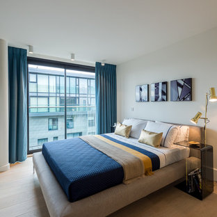 Inspiration for a contemporary guest bedroom in London with white walls, light hardwood flooring and beige floors.